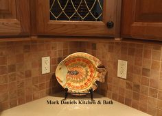 a bowl sitting on top of a kitchen counter next to a wine glass rack and wooden cabinets