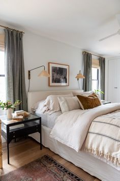 a white bed sitting next to a window in a bedroom