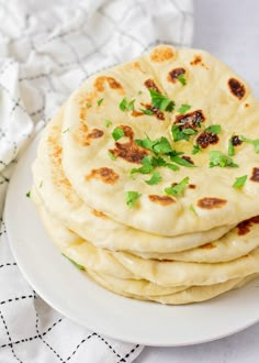 a stack of pita bread sitting on top of a white plate