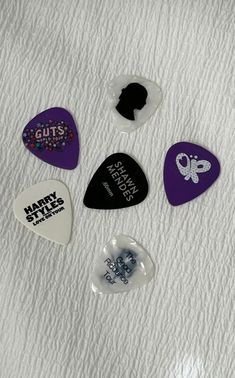 six guitar picks are laying on a white sheet