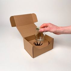 a person opening a box with a glass in it