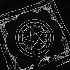 a black and white photo of a pentagram seal on a cloth with writing around it