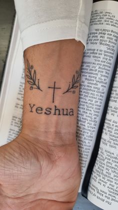 a person's foot with a cross and the words yeshua tattooed on it