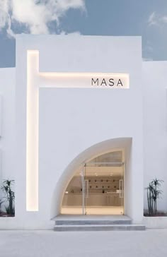 the entrance to masa is lit up with white lights and palm trees in the background