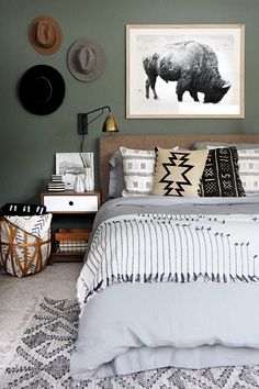 a bedroom with green walls and pictures on the wall above the bed, along with other decor items