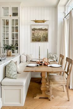 a kitchen with a table and bench in it