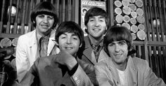 the beatles posing for a black and white photo in front of some wood slices on display