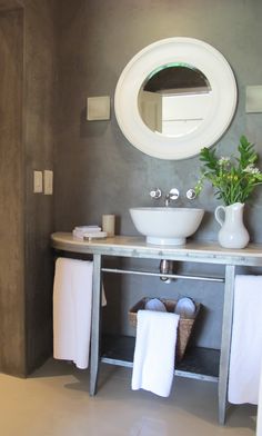 a bathroom with a sink, mirror and towel rack on the wall next to it