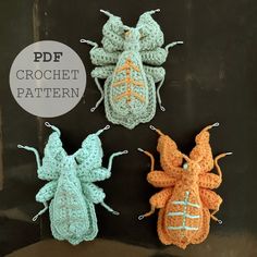 three crocheted bugs sitting next to each other on top of a black surface