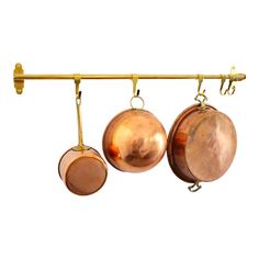 three copper pots hanging from a metal bar