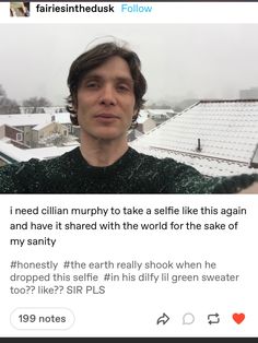 a man is looking at the camera in front of snow covered rooftops