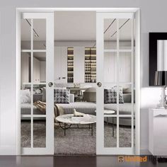 a living room with white furniture and glass doors leading to another room that has a couch