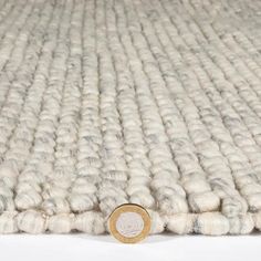 a close up of a rug on the floor with a button in front of it