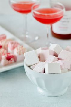 two glasses of wine and some marshmallows in a bowl