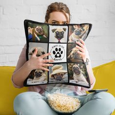 a woman sitting on a couch holding up a pillow with pictures of pug dogs