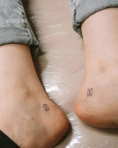 two people with small tattoos on their legs and one has a bow at the bottom