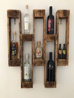 three wooden crates with bottles in them on the wall next to each other and one is empty