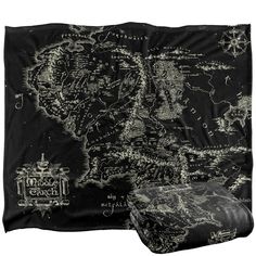 a black and white blanket with an image of the middle earth map in gold on it