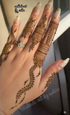 a woman's hand with henna tattoos on it