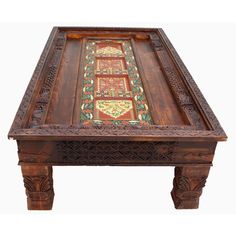 an ornate wooden table with intricate carvings on the top and bottom, inlaided with floral designs