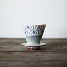 a white and blue bowl sitting on top of a wooden table