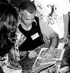 a group of people sitting around a table looking at papers on top of each other