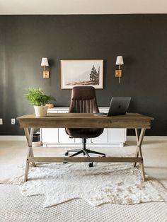 a desk with a laptop on it in front of a green wall and white carpet