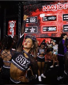 a group of cheerleaders standing in front of a stage