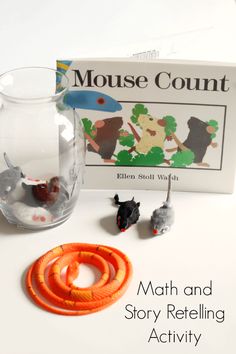 the mouse count book is next to a glass vase with orange rings in front of it