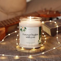 a candle sitting on top of a table next to a string of lights and a guitar