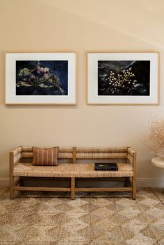 two framed pictures hang on the wall above a couch in a room with patterned flooring