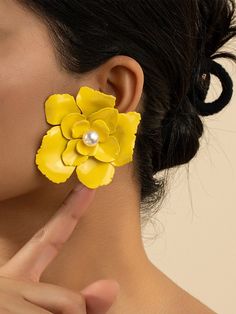 a close up of a person wearing ear clips with flowers on the back of their ears