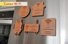 four wooden magnets on the side of a refrigerator with wi - fi attached to them