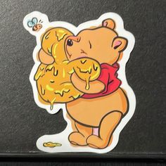 a winnie the pooh sticker sitting on top of a laptop computer screen with honey dripping out of it