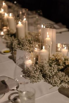 the table is set with candles, flowers and other decorations for a wedding or special event