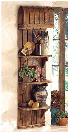 a wooden shelf with pots and vases on it