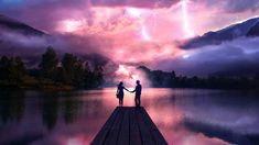 two people holding hands on a dock in front of a lake with mountains and lightning