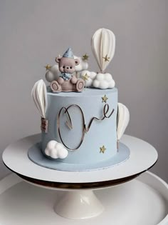 there is a cake that has a teddy bear in it on the top and some hot air balloons