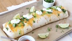 two burritos are sitting on a tray with salsa