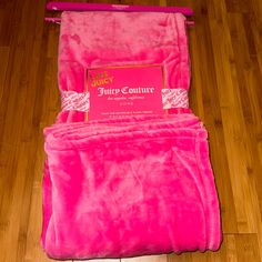 a pink blanket sitting on top of a wooden floor