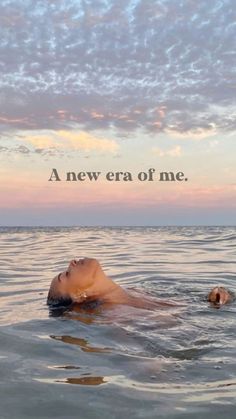 a woman floating in the ocean with her head above the water and an inscription that reads, a new era of me