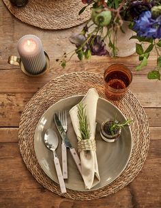 the place setting is set with silverware and napkins, along with a candle