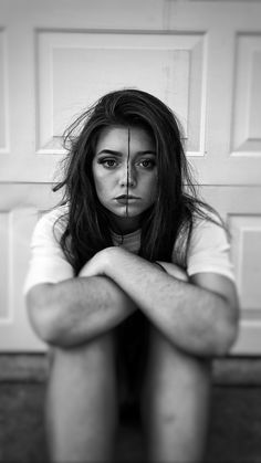 a woman sitting on the floor with her legs crossed in front of her face and hands behind her head