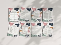 a set of six butterfly wedding seating cards on top of a white table with shadows