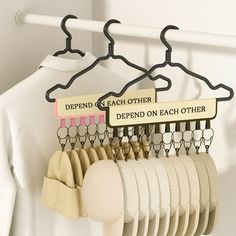 there is a rack with clothes hanging on it and two hangers attached to each other