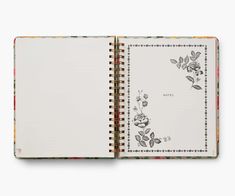 an open notebook with flowers and leaves on the pages, in front of a white background