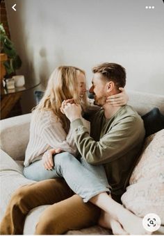 a man and woman sitting on top of a couch