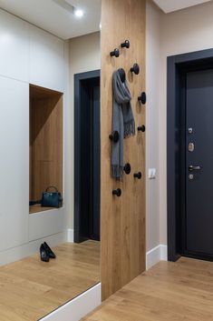 a pair of black shoes sitting on top of a wooden floor next to a door