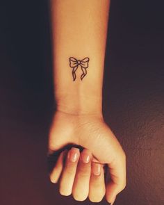 a small bow tattoo on the wrist is shown in an instagramtion post from twitter