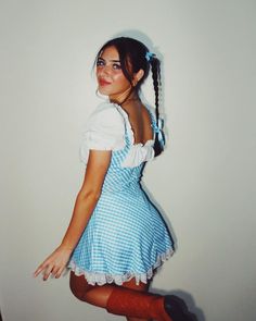 a woman in a blue and white dress posing for the camera